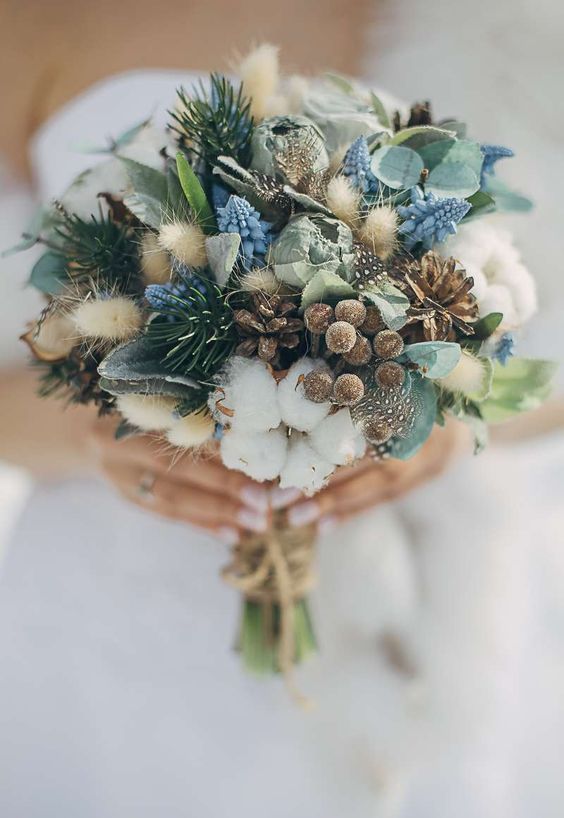 a non-floral winter wedding bouquet that includes pinecones, berries, bunny tails, thistles, evergreens and cotton is amazing