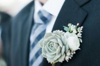 a pale winter wedding boutonniere of a succulents, white blooms and berries is a pretty accessory to rock