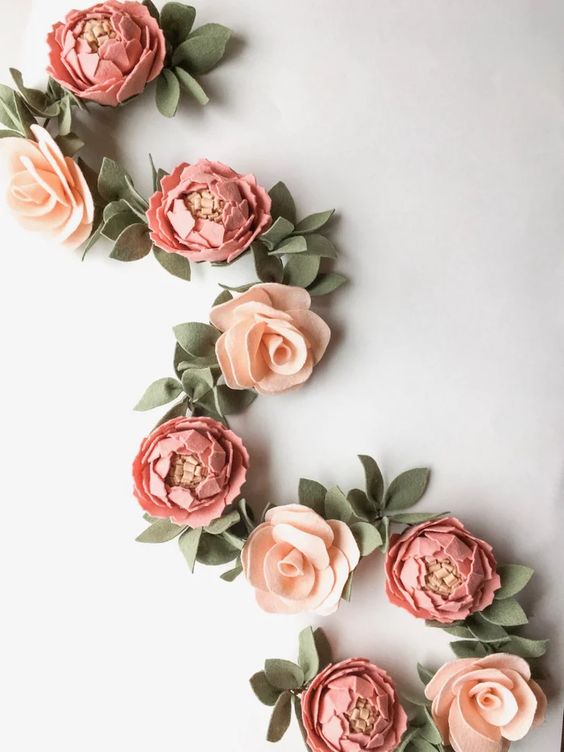 a peony and rose felt garland with leaves is a cool and simple decoration for a wedding, especially in spring or summer