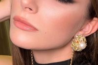 a perfect glam holiday makeup with a glossy pink lip, gold metallic eyeshadow and wings and lash extensions