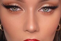 a perfect glam holiday makeup with a red lip, gold metallic eyeshadow, wings and lash extensions