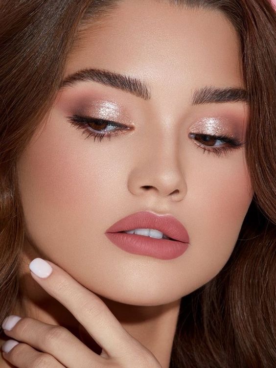 a polished holiday makeup with a matte pink lip, pink and metallic eyeshadows and a touch of pink blush