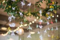a pretty greenery and bloom chandeleir with pastel paper cranes for decorating the venue