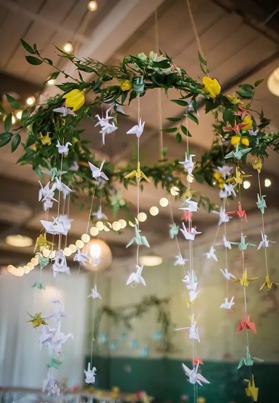 a pretty greenery and bloom chandeleir with pastel paper cranes for decorating the venue