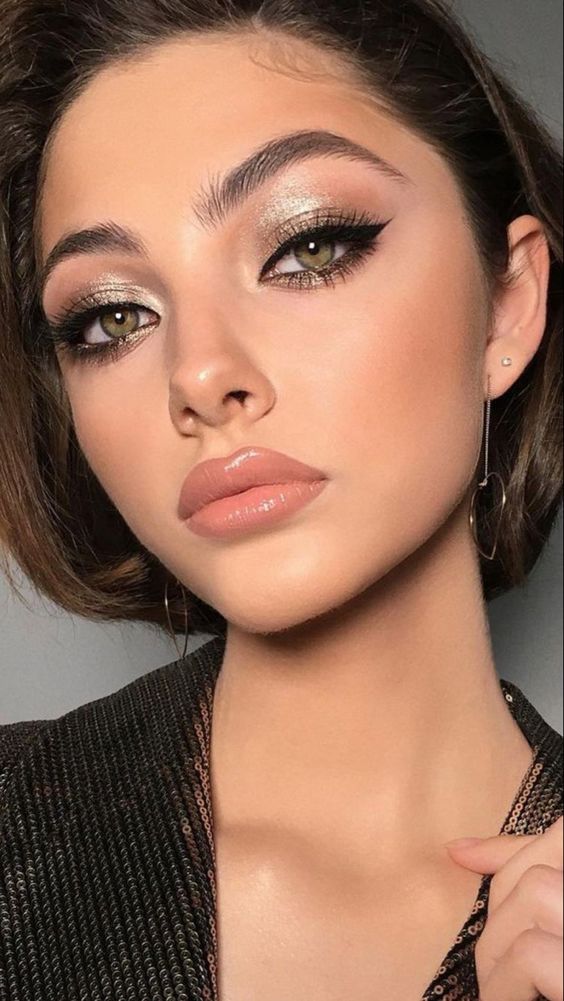 a pretty holiday makeup with a glossy nude lip, perfect tone and blush, white eyeshadow, wings and lash extensions