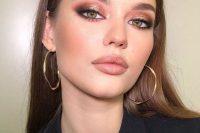 a pretty holiday makeup with a glossy nude lip, pink smokeys with metallic touches, wings and a touch of blush