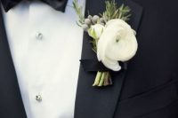 a refined neutral wedding boutonniere of white blooms, berries and greenery for accessorizing a tux