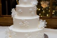 a refined white wedding cake decorated with sugar snowflakes is a gorgeous idea for a winter wedding