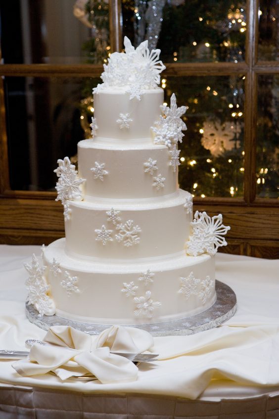 a refined white wedding cake decorated with sugar snowflakes is a gorgeous idea for a winter wedding