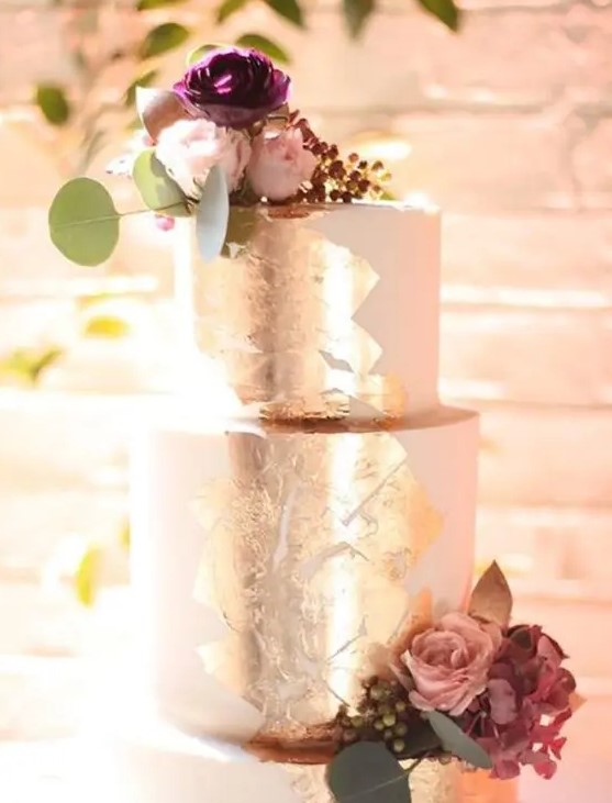a refined white wedding cake with silver leaf, with pink and mauve blooms and greenery is a beautiful idea for a summer or fall wedding