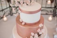 a romantic wedding cake in white and rose gold, with sugar sakura branches is a chic and cool idea