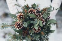 a rustic winter wedding bouquet of snowy pinecones, greenery and evergreens plus some white flower fillers is a cool idea