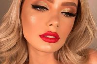 a shiny and glam Christmas makeup with a red lip, gold metallic eyeshadow, wings and accented eyebrows plus highlighter