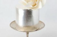 a silver leaf wedding cake with a single oversized white sugar bloom on top is a very pretty and refined idea for a modern wedding