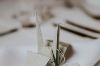 a simple origami crane with a tag is a lovely seating card with a touch of whimsy, it looks cute