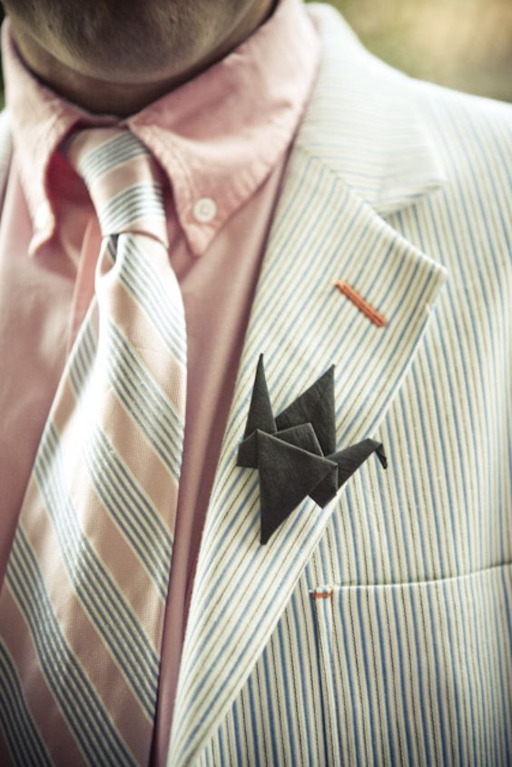 a striped suit, a pink shirt, a striped tie and a black origami boutonniere are a lovely combo for a wedding
