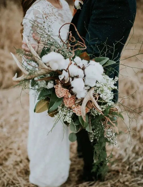 a textural woodland bouquet with antlers, cotton, gold and green leaves, pink and white blooms