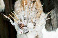 a unique frozen winter wedding bouquet with cotton, snowy branches, twigs and grasses is a great idea for a winter bride