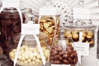 a wedding chocolate bar with various types of candies and chocolate in jars and tags is amazing for a chocolate-loving couple