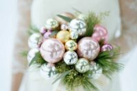 a winter holiday wedding bouquet composed of pastel and metallic ornaments and some greenery is a gorgeous idea