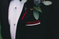 a winter wedding boutonniere of burgundy blooms, thistles and greenery, a burgundy bow tie and handkerchief for a winter look