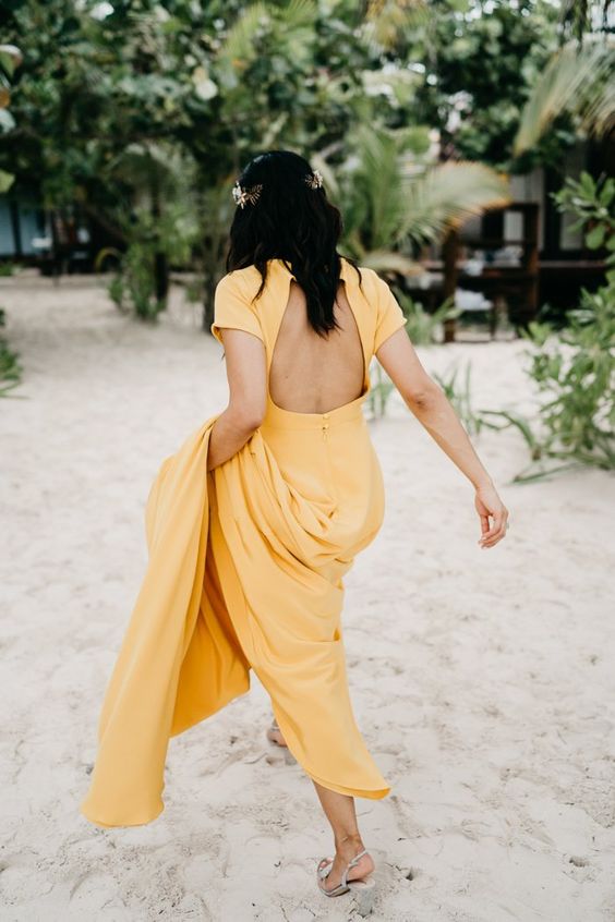 a yellow A-line wedding dress with a cutout back, short sleeves and a train for a tropical bride