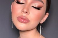 an eye-catchy holiday makeup with a glossy nude lip, smokey eyes with a touch of metallic eyeshadow, wings and lash extensions