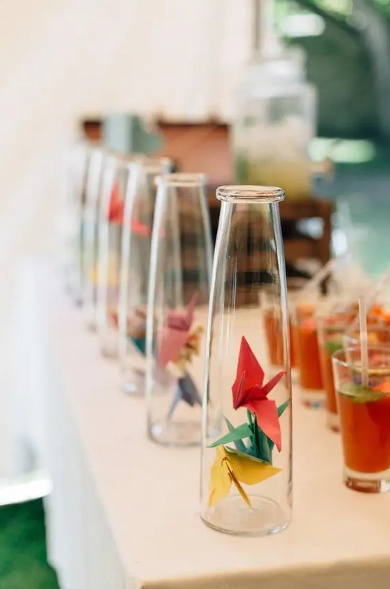 bottles with colorful paper cranes for decorating a drink bar or a station at your wedding
