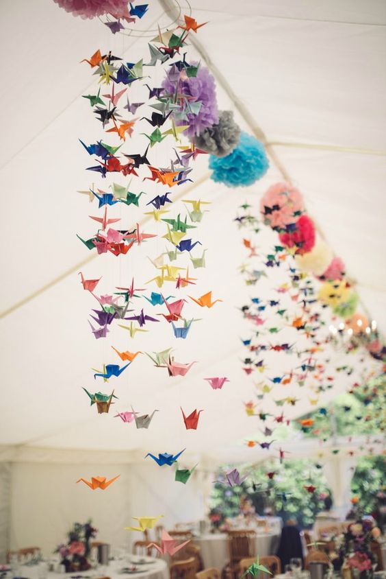 colorful paper pompoms and paper cranes are amazing for stylish a wedding reception at a relaxed and laid-back wedding
