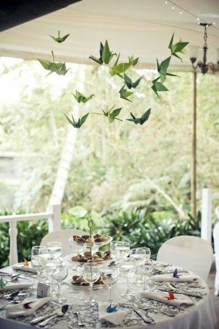 green origami cranes hanging over a reception table will give it a touch of whimsy and some interest