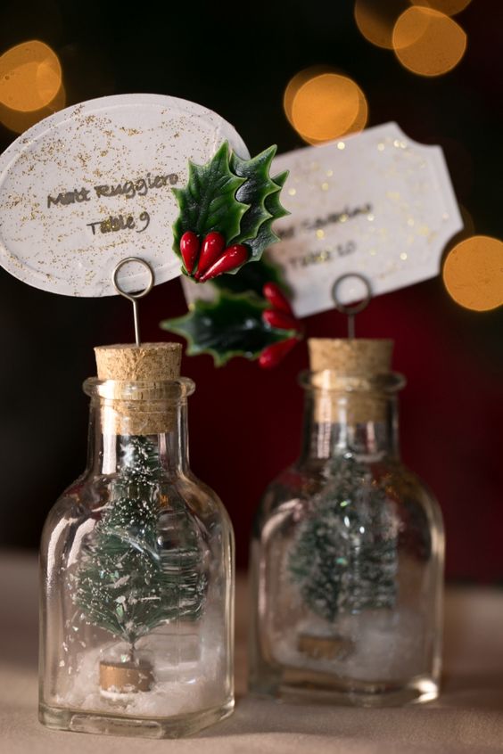 mini Christmas trees in bottles, with cool glitter tags and leaves and berries are gorgeous little favors