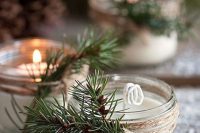 mini candles with fresh fir twigs are lovely holiday-inspired wedding favors for your Christmas celebration