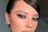 shiny holiday makeup with a glossy nude lip, a touch of blush, silver eyeshadow, lash extensions and highlighter