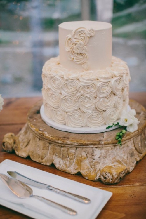a tan buttercream wedding cake with a sleek and a flower tier is a chic and cool idea with a subtle touch of color
