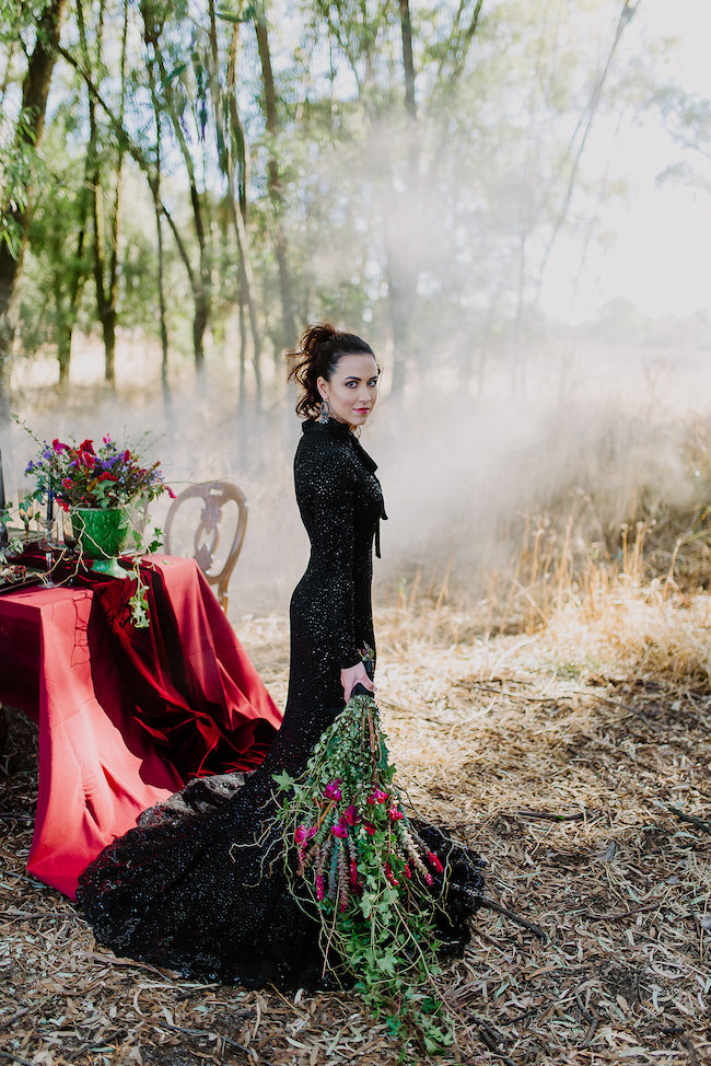 a black sparkling mermaid wedding gown with a high neckline, long sleeves and a train