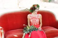 a boho-inspired red wedding dress with a detailed bodice and no sleeves plus a floral crown