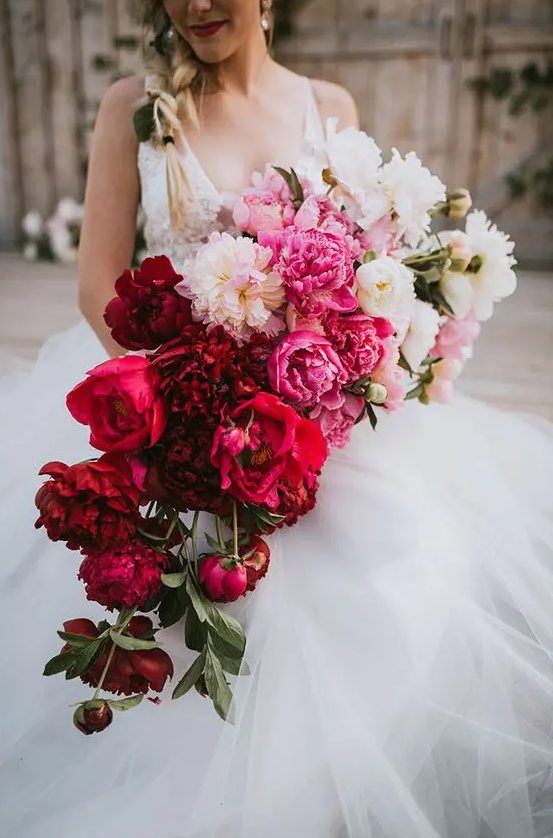 a bold cascading wedding bouquet from white and light pink to pink, red and burgundy is a breathtaking idea