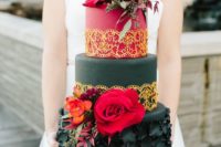a bold red and black wedding cake with sugar flowers, gold touches, hot red blooms has a wow effect