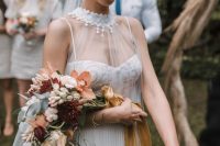 a cascading wedding bouquet with rust, burgundy and blush blooms and greenery plus mustard ribbons is a chic and bold idea for a fall bride
