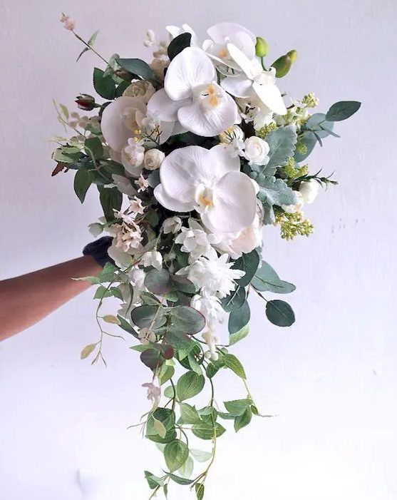 a chic textural cascading wedding bouquet with white orchids and various greenery for a chic look