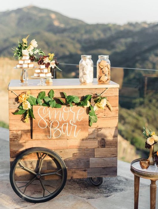 a chic wedding s'more bar with greenery and blooms fully built of pallet wood is a gorgeous option