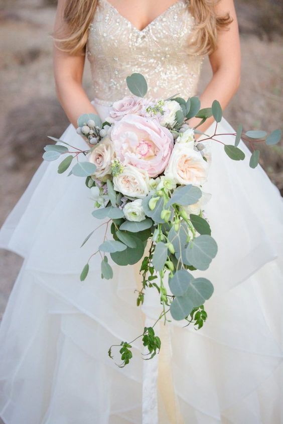a delicate cascading wedding bouquet of neutral and blush blooms, berries and greenery is a stylish idea for spring and summer