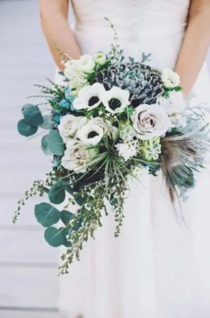 a delicate cascading wedding bouquet with white anemones, pale roses, herbs and greenery shows off much texture and interest
