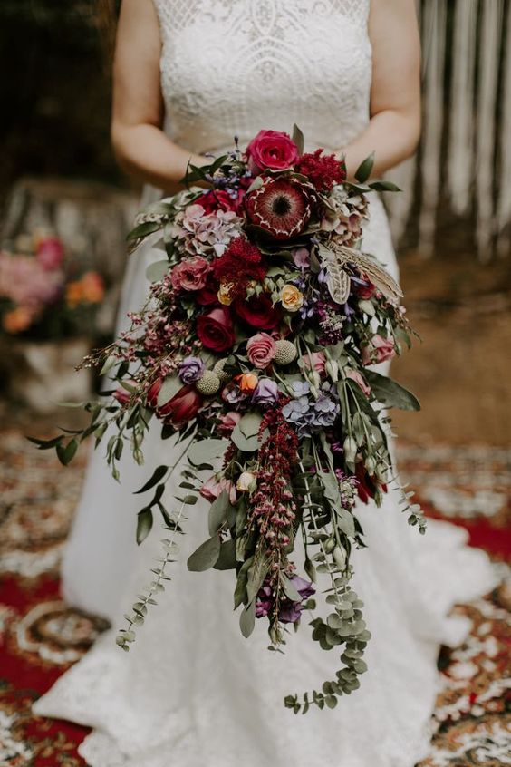 a fantastic cascading wedding bouquet of burgundy, pink, yellow blooms and lots of greenery is a lovely idea for a fall wedding