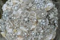 a glam sphere wedding bouquet of silver brooches and pearls, with leafy and flower motifs is a gorgeous idea for a winter bride