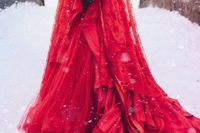 a hot red wedding ballgown with a plunging neckline and a train,, a matching veil and a crown plus a red lip