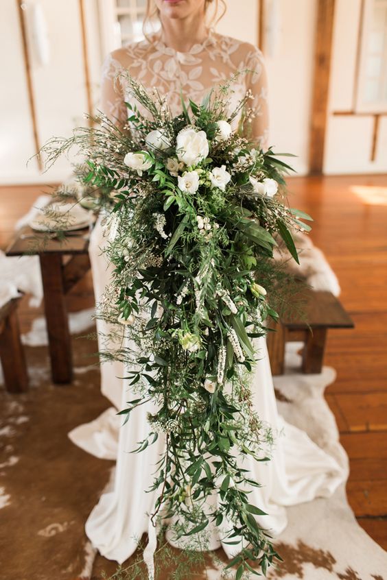 a jaw-dropping cascading wedding bouquet of only white blooms and greenery that goes down to the floor is a gorgeous statement