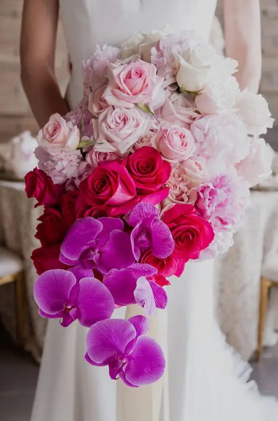 a jaw-dropping wedding bouquet from white to light pink, fuchsia and bold purple and a cascading effect is a bright idea