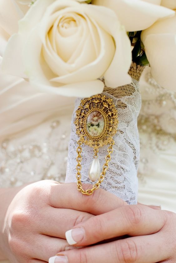 a kace wedding bouquet wrap with a large vintage brooch with a pearl is a fantastic idea for a vintage bride