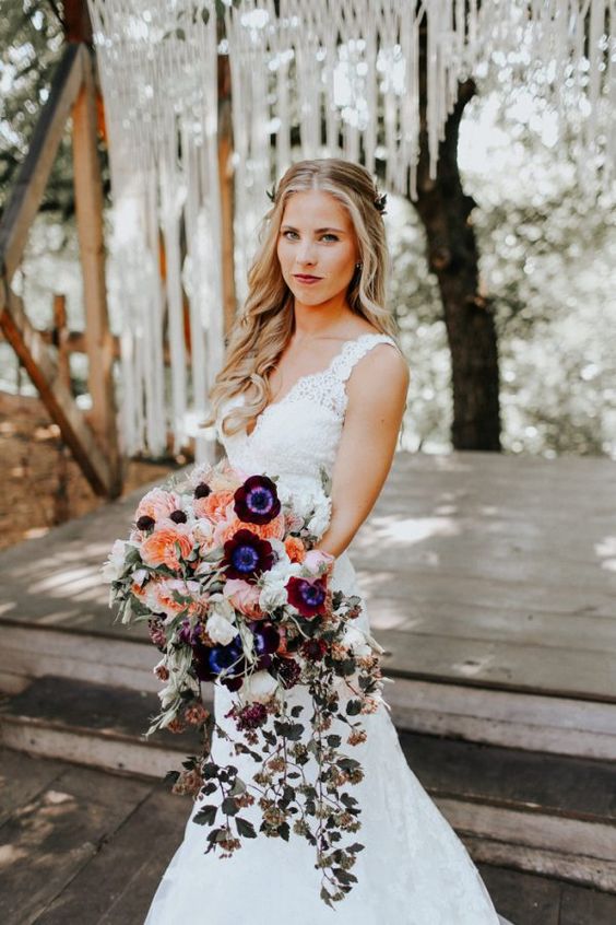a lovely and catchy cascading wedding bouquet with white, orange, burgundy blooms and some cascading ones plus greenery for a boho bride